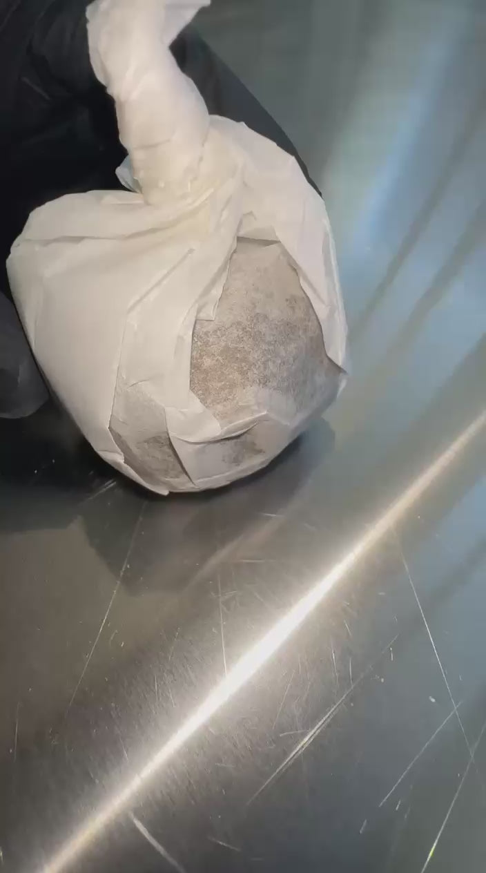 Hash CBD Premium  Hashis Premium avvolto in carta bianca su superficie metallica, ideale per appassionati di cannabis light e dry ice hash.